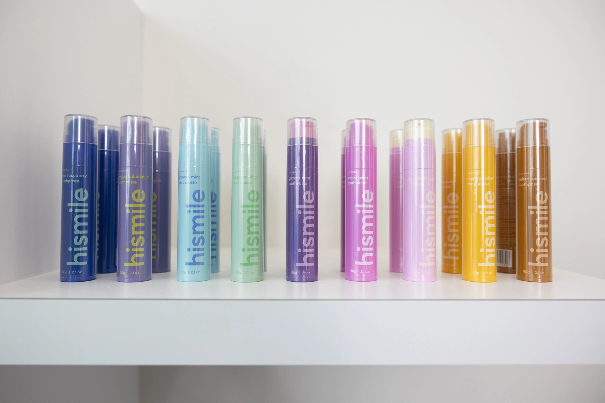 a row of colorful hismile oral care and teeth whitening products arranged on a shelf